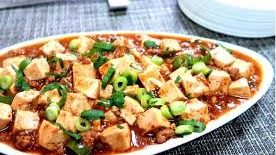 Mapo doufu or mapo tofu (éº»å©†è±†è…) is a popular Chinese dish from Sichuan province. It consists of tofu set in a spicy sauce, typically a thin, oily, and bright red suspension, based on douban è±†ç“£ (fermented broadbean and chili paste) and douchi è±†è±‰ (fermented black beans), along with minced meat, usually pork or beef. Variations exist with other ingredients such as water chestnuts, onions, other vegetables, or wood ear fungus.Source: https://en.wikipedia.org/wiki/Mapo_doufu